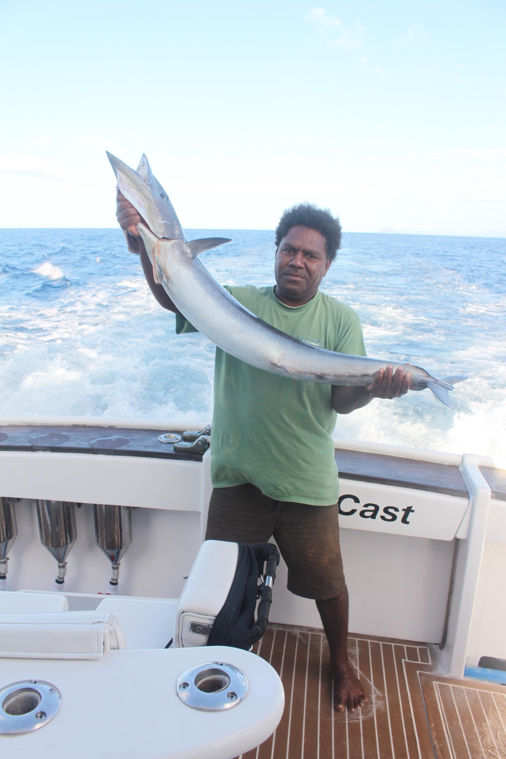 Combining work and play, Iarawai Phillip shows off his proud catch during the survey 