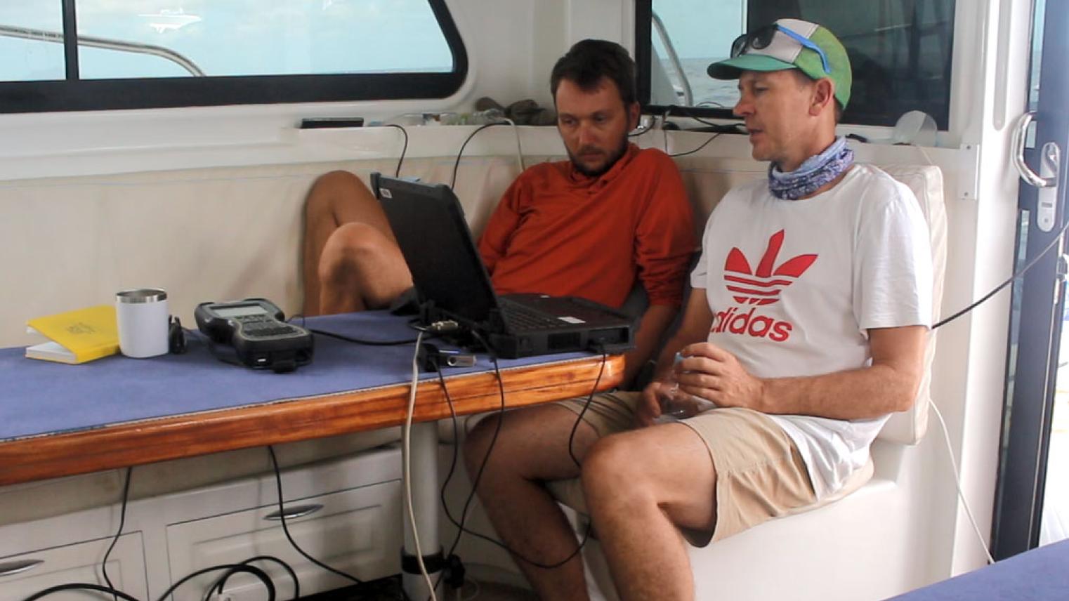Sönke Stern (L) and Brendan Hall on board the Amalu checking incoming data